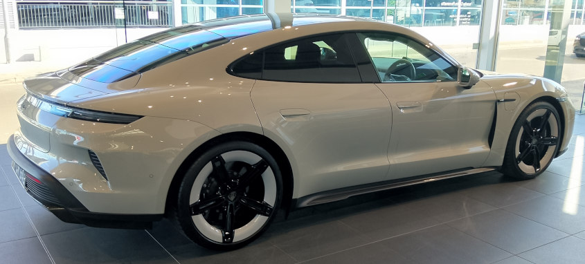 Porsche Taycan in white with white trimmed wheels, somewhat imitating white-wall tyres.